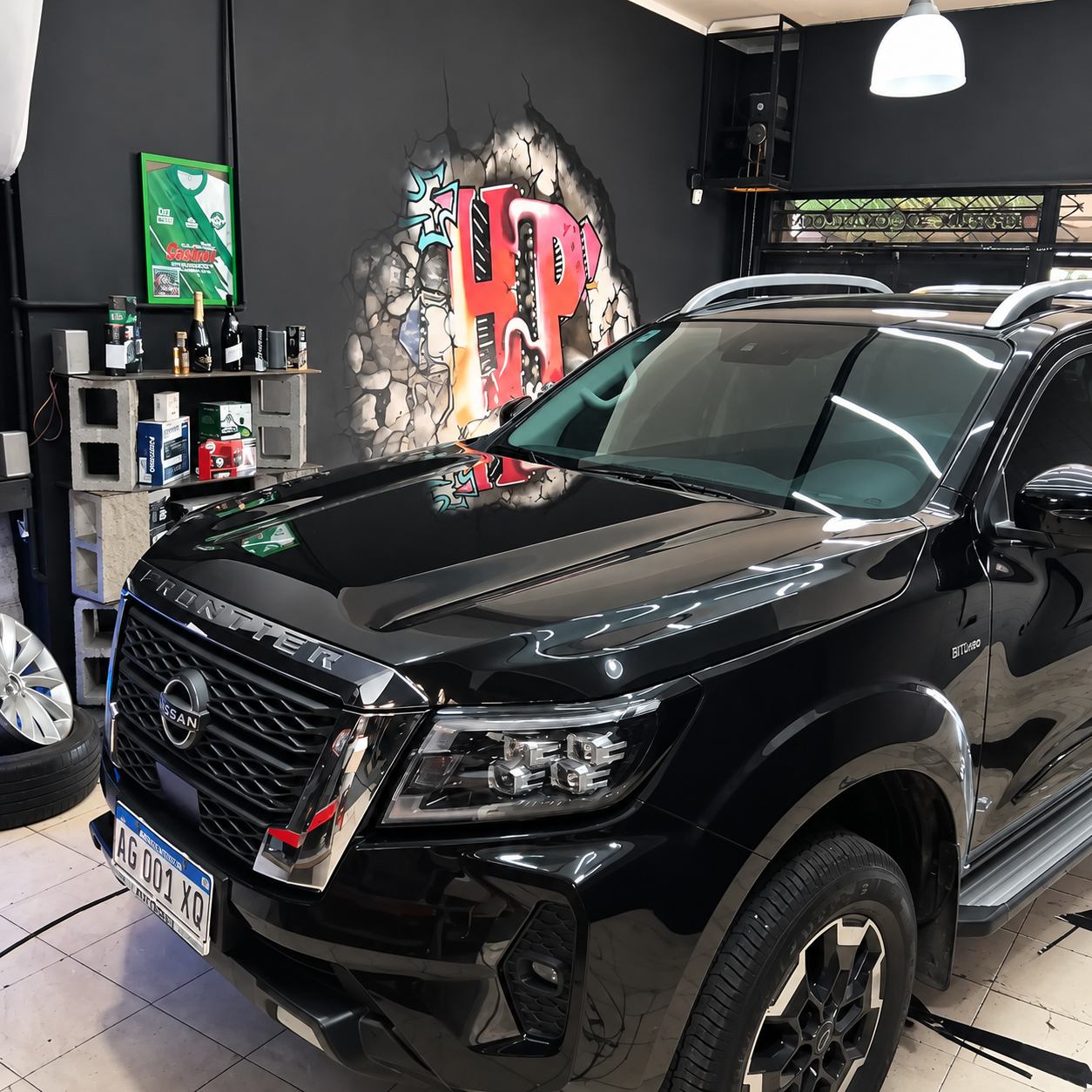 Camioneta Nissan negra atendida en HP Film